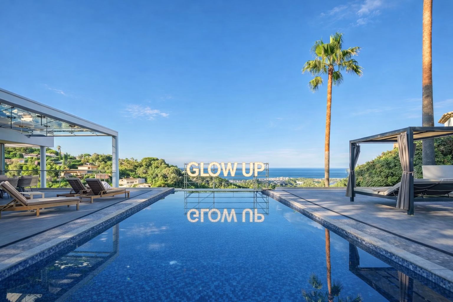 Piscine Villa Glow Up en plein jour avec lettres GLOW UP, vue mer panoramique et ciel bleu
